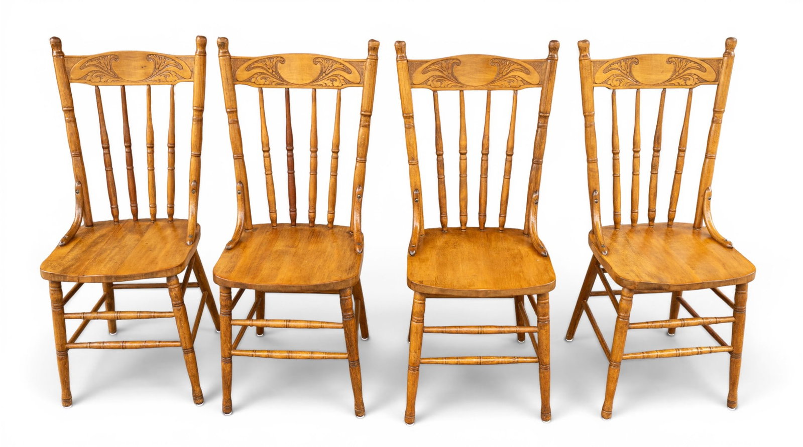 Set of 4 Carved Spindle Back Dining Chairs: Four wooden spindle-back chairs with carved details on the backrests. Each chair measures approximately 15 inches wide by 15 inches deep by 39 inches high.