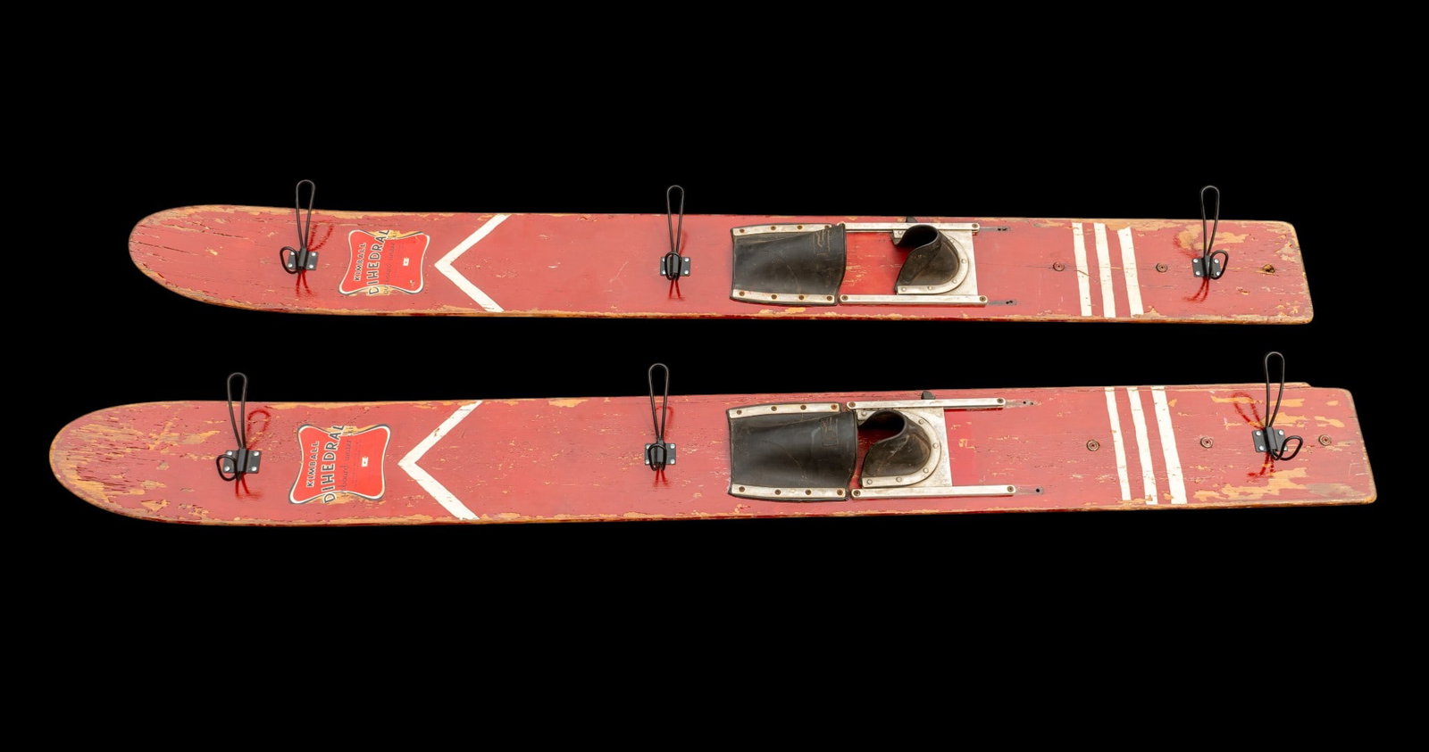 Kimball Dihedral Outboard Water Skis: Kimball Dihedral outboard water skis approximately 65 inches long. Constructed from wood with red paint featuring white and gold accent designs. One ski includes a rubber foot strap and adjustable