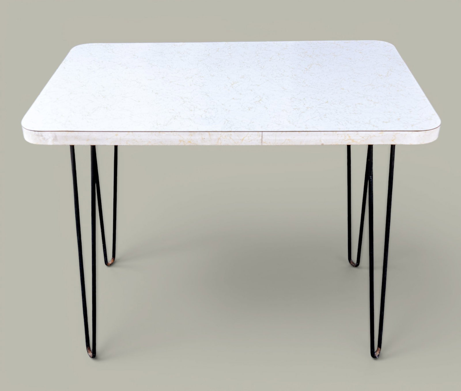 Mid Century Modern Formica Occasional Table: Mid century modern rectangular kitchen/occasional table featuring white and gold formica top with black hairpin metal legs. Measures approx. 32.25" W x 20" D x 28.5" H.