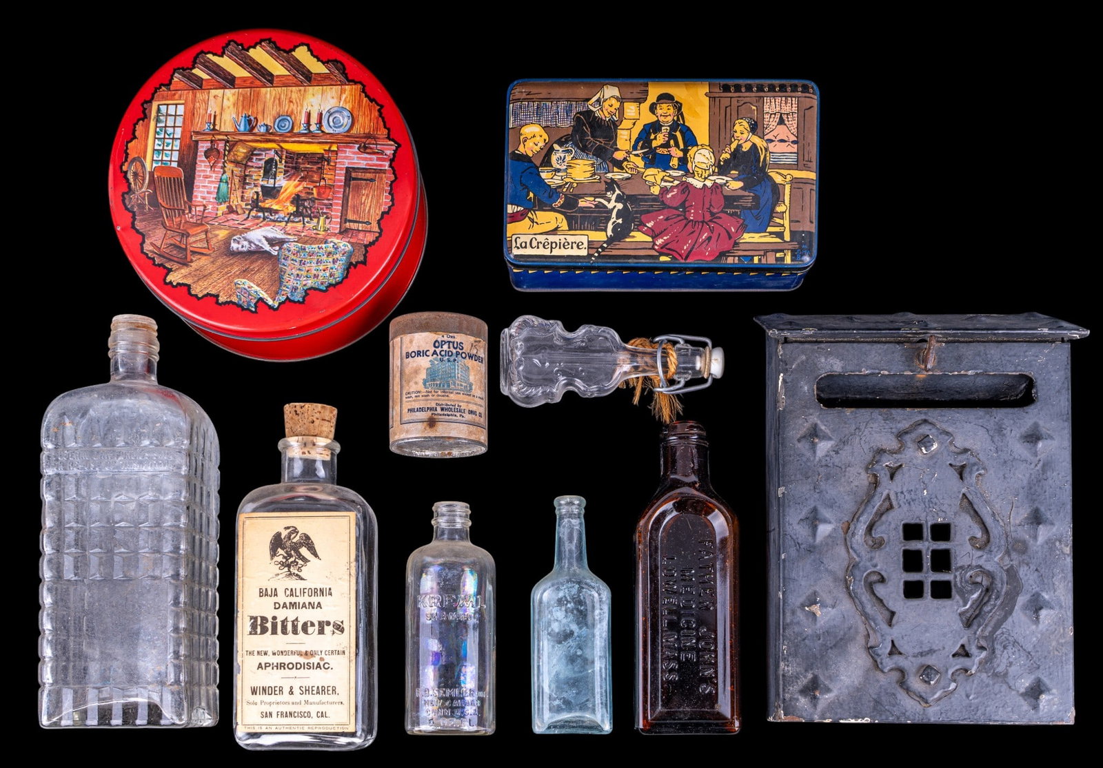 Antique Cast Iron Letter Box, Embossed Bottles: Decorative cast iron wall-mounted letter box with hinged lift-top lid, mail slot, and Gothic-inspired relief decoration. Accompanied by a group of embossed antique and vintage glass bottles including 