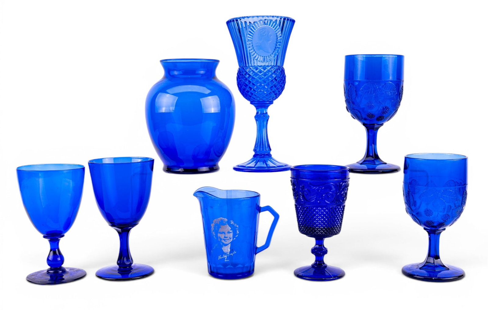 Vintage Coblat Blue Glass Stemware: An assortment of vintage cobalt blue glass stemware and vase including an Avon Fostoria George Washington water goblet, and more.