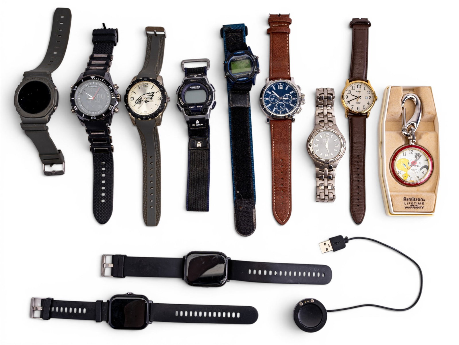 Vintage Wrist Watches and Smart Watches: A collection of vintage men's wrist watches including a Philadelhpia Eagle wrist watch, an Embassy by Gruen, Timex IronMan, an Armitron Looney Toons Sylvester and Tweety Bird pocket watch with origina