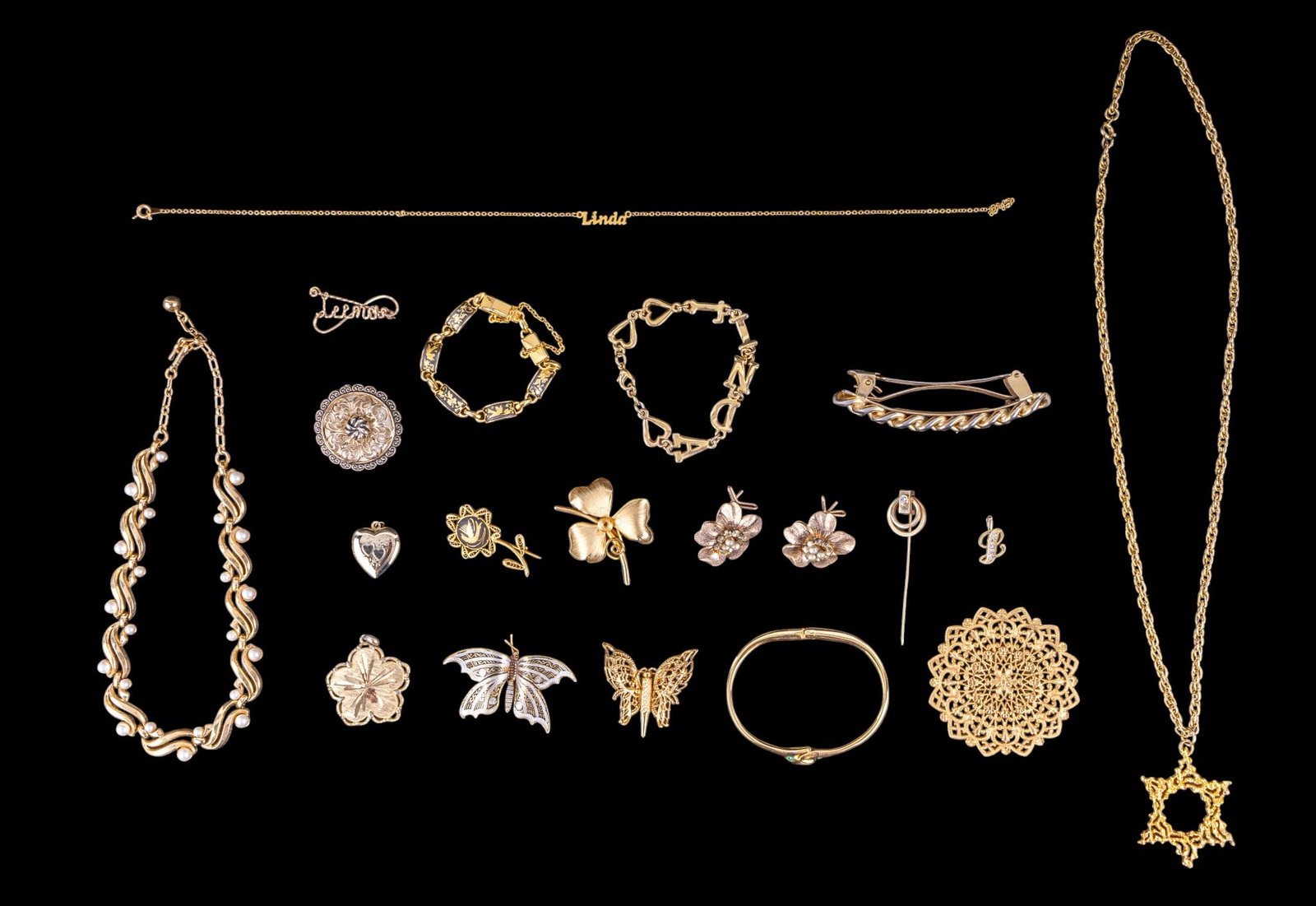 Crown Trifari and Gold Toned Jewelry: A collection of gold toned jewelry including a vintage Crown Trifari gold tone swoop and faux pearl necklace, a personalized bracelet and necklace that read 'Linda', Damask style brooches, floral earr