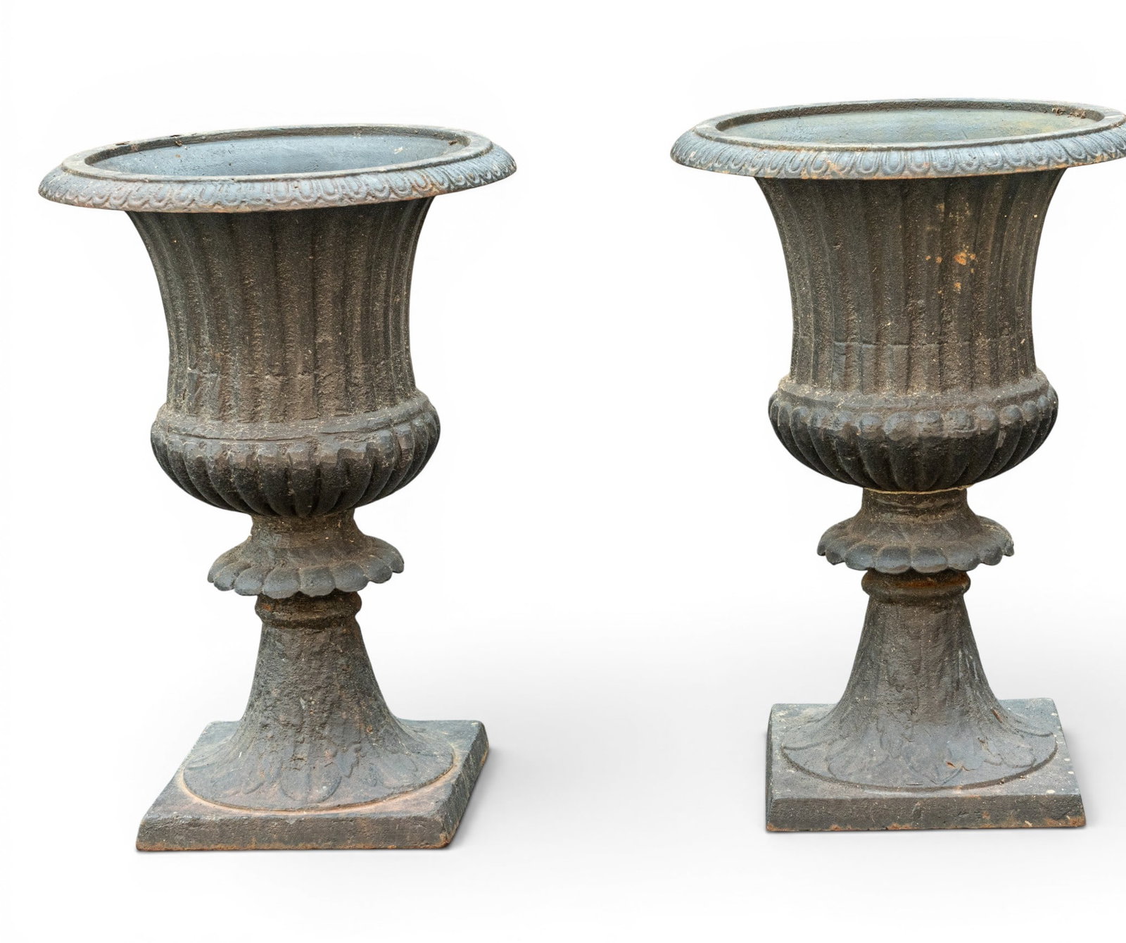 Pair of Cast Iron Garden Urns: Pair of cast iron garden urns with fluted and curved rims. Each measuring approx. 20.5" H x 14" Diameter. One urn has some loss to rim.