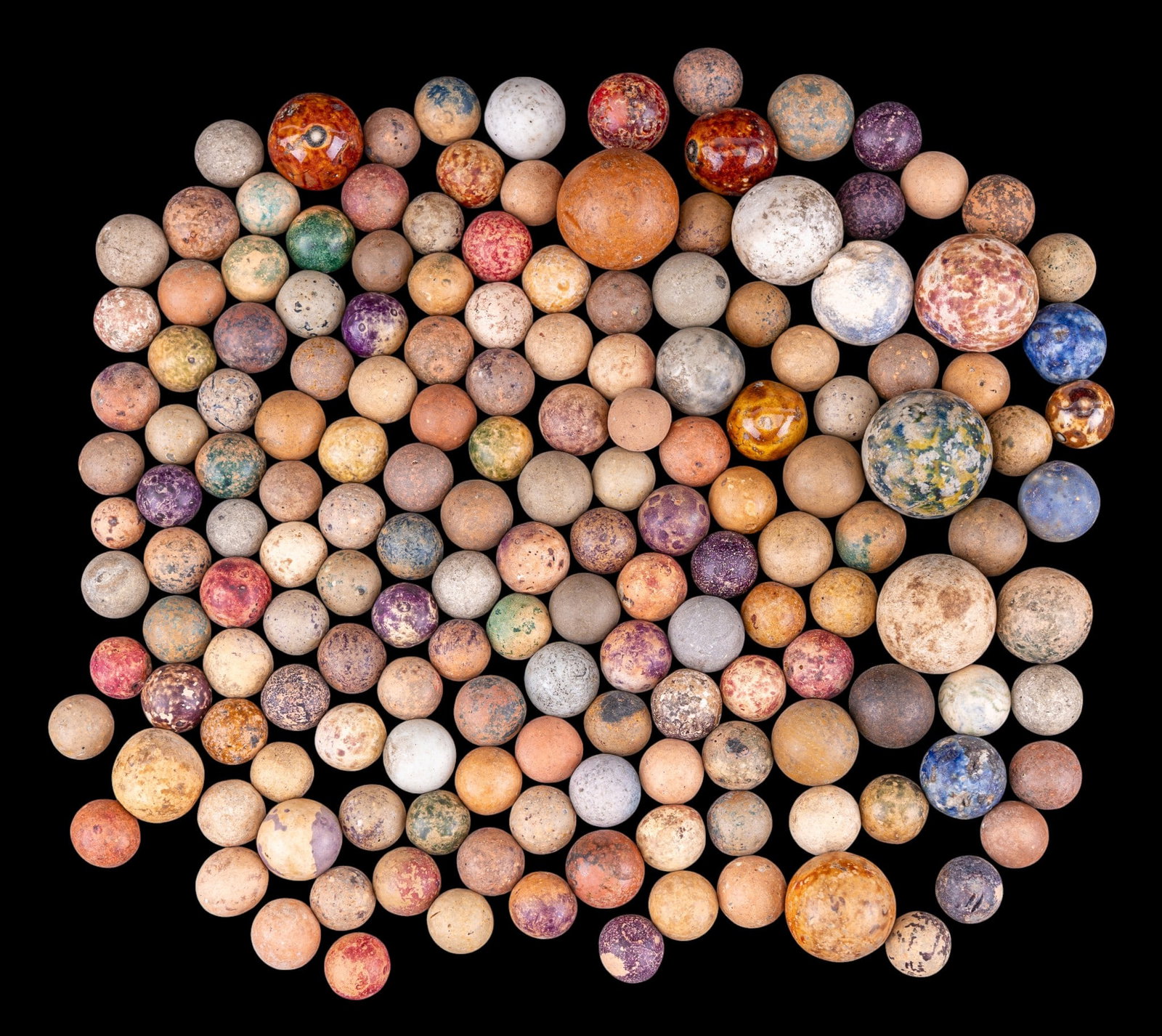 Clay Marble Grouping: An assortment of clay marbles in various sizes, colors, and mottled finishes.