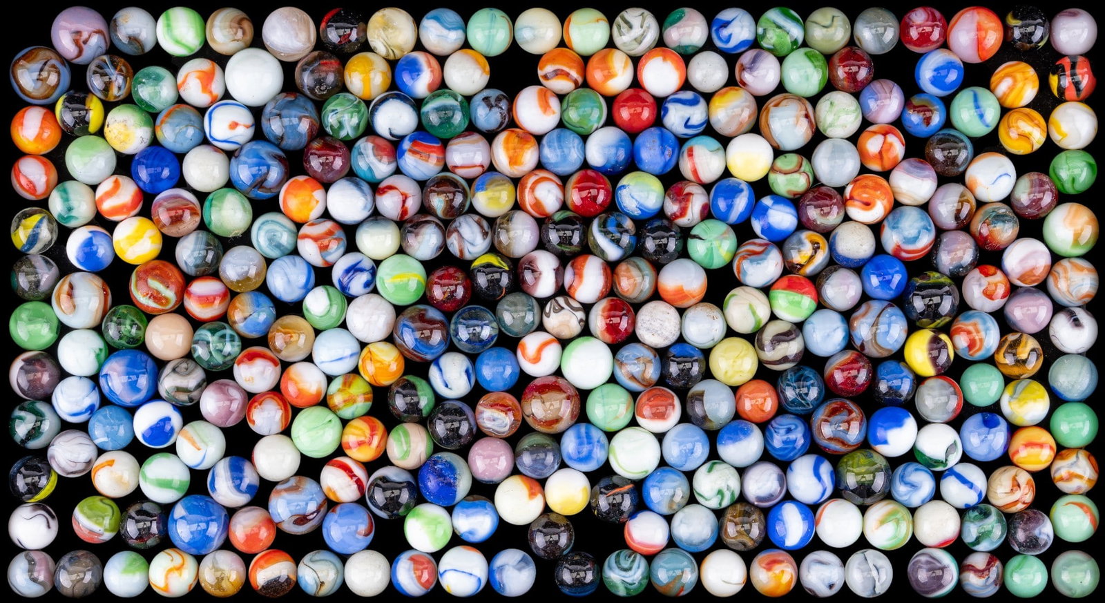 Assortment of Glass Marbles: Assortment of glass marbles in various colors, sizes, and patterns, including opaque, translucent, swirled, ribbon, and multicolored examples.