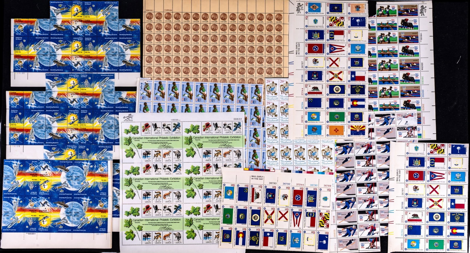 Uncanceled U.S. Postage Stamp Sheets: Group of uncanceled U.S. postage stamp block sheets including themes such as Canadian International Philatelic Exhibition, Indian Head Pennies, Norman Rockwell, USA Olympics 1980, and USA Space