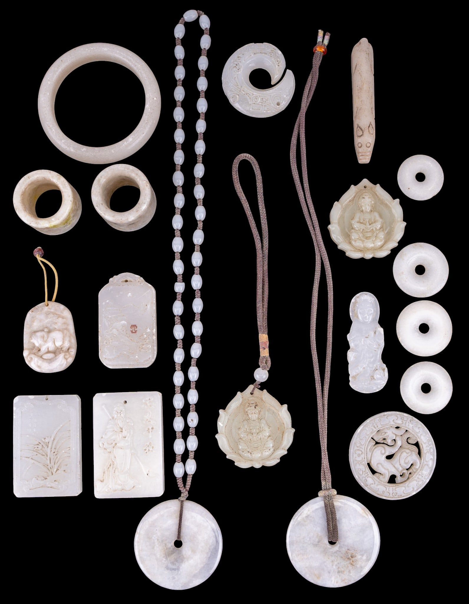 Chinese White Hardstone Medallions and More: A collection of Chinese white hardstone including a bangle, medallions and pendants, and archer's thumb guards.