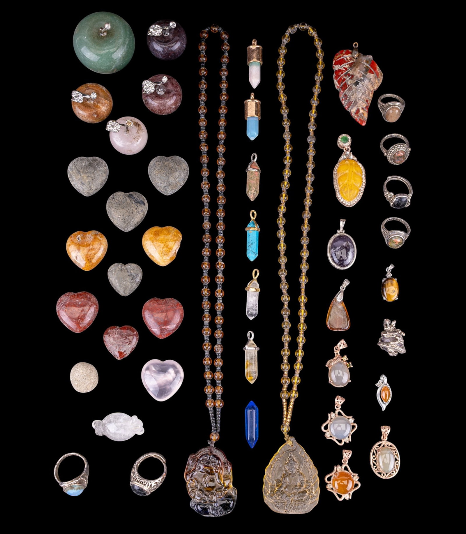 Chinese Stone Paperweights, Pendants, and More: A collection of Chinese natural stone paperweights including rose quartz and green hardstone, glass Buddha pendants, stone and glass jewelry pendants, and rings.