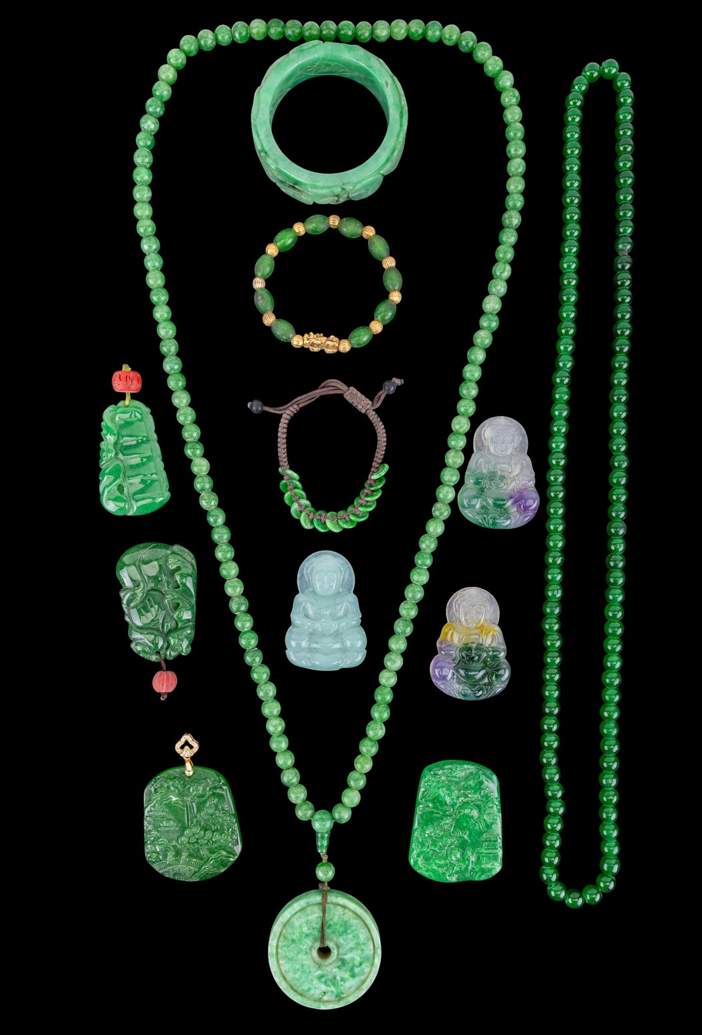 Chinese Green Hardstone Medallions and Jewelry: A collection of Chinese green hardstone Buddha and bat medallions, a dragon and phoenix bangle bracelet, a beaded stretch bracelet, and strands of green hardstone beads. Bangle diam. is approx. 2"