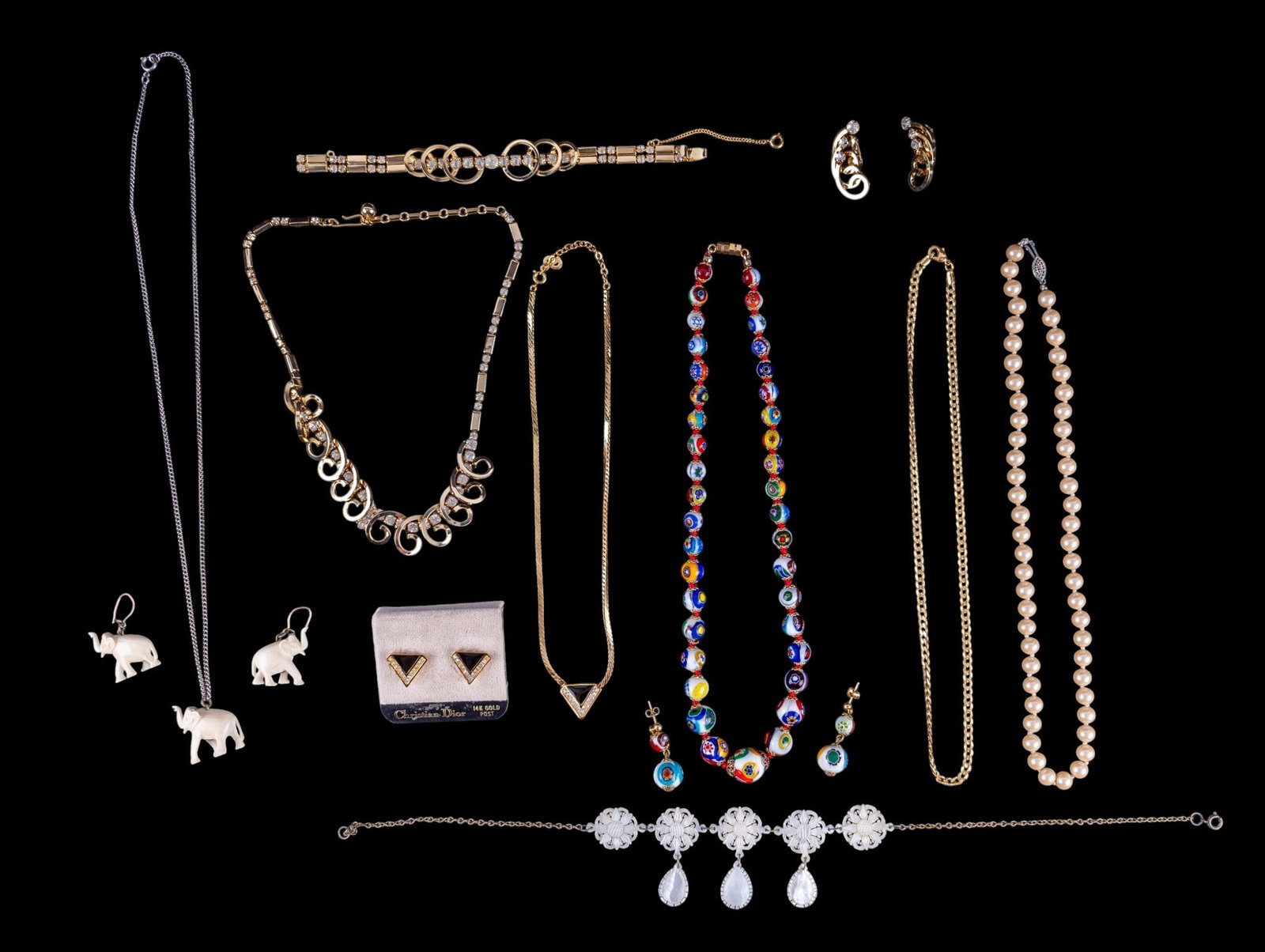 Christian Dior and Other Jewelry Sets: A gold tone, rhinestone, and black onyx Christian Dior stud earring and necklace set, a millefiori necklace and earring set, a pearl necklace with sterling fish hook clasp, natural material elephant e