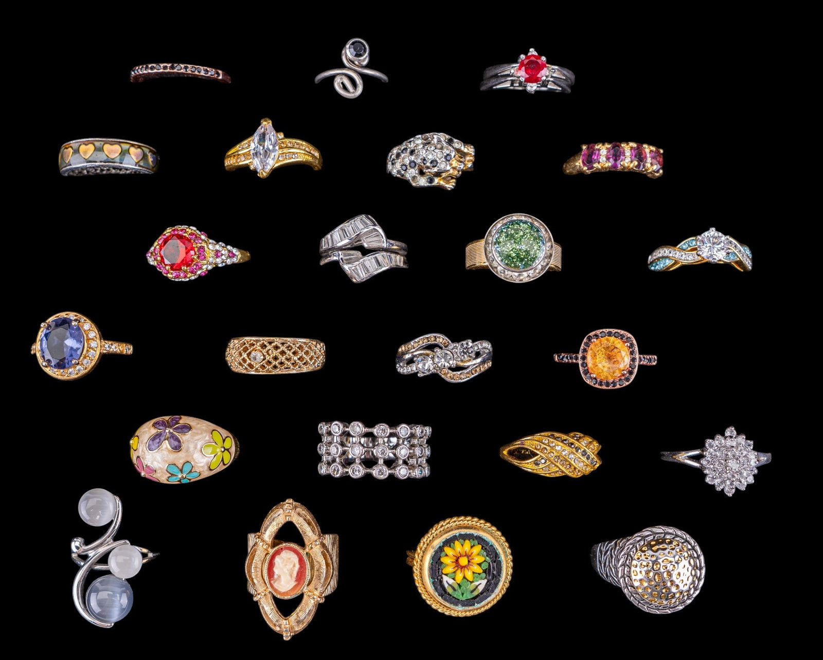 Costume Rings (23): A collection of 23 costume rings featuring micro mosaic, rhinestones, enamel, a contemporary silver tone and red stone flip ring, a cameo style by Sarah Coventry, and more. Sizes range from 5 to 11.