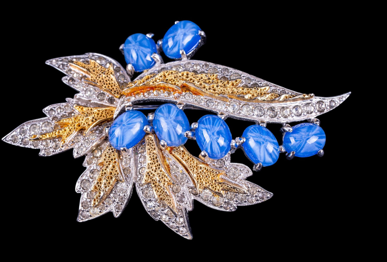 Vintage Polcini Brooch: A vintage gold and silver tone brooch featuring faux star sapphires and clear pave rhinestones, by Polcini.