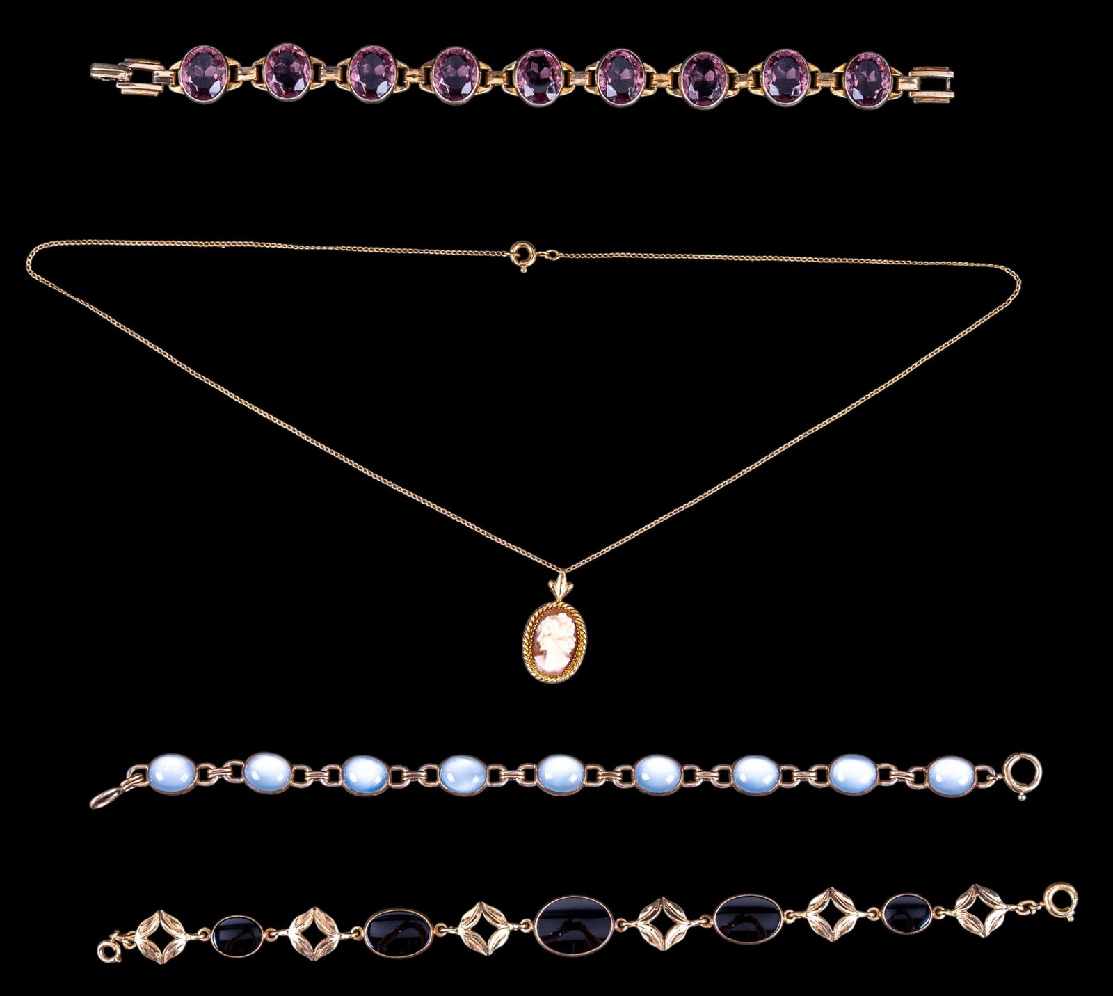 Victorian Gold Filled Jewelry: A collection of Victorian gold filled jewelry including a 12K GF and onyx bracelet, a 10K GF cameo pendant and chain, a faux moonstone and 12K GF bracelet, and a 10K GF and amethyst bracelet.