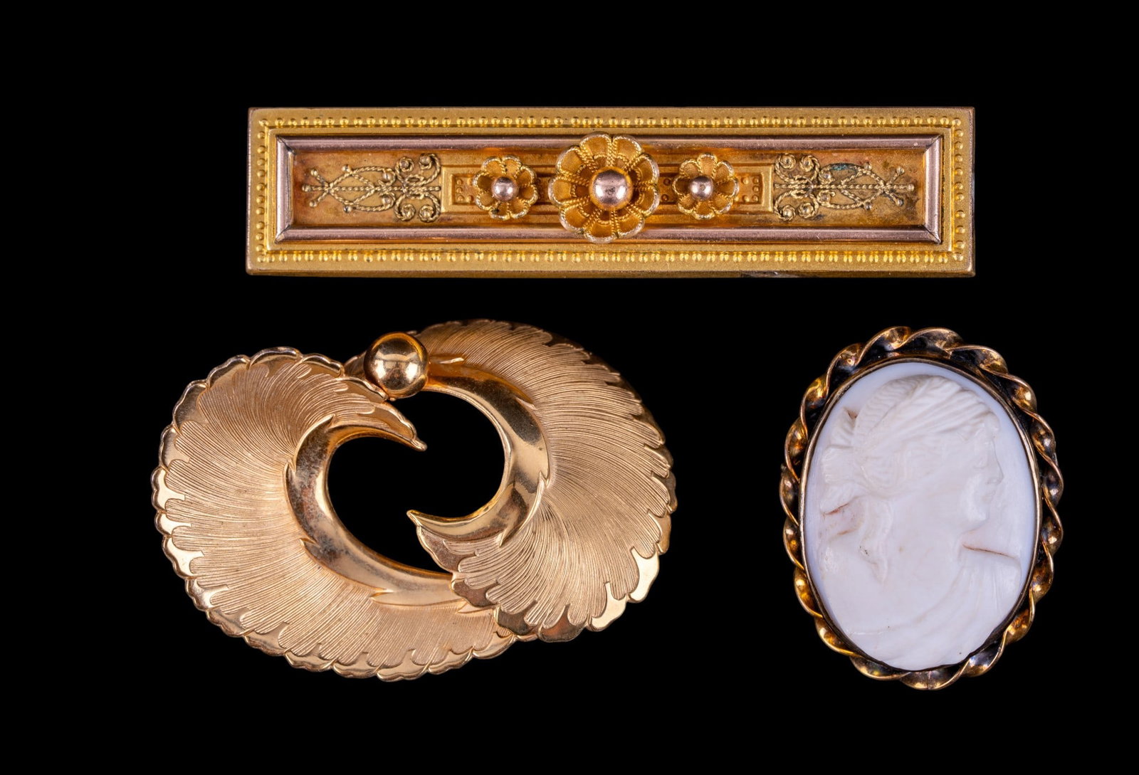 Victorian and Other Jewelry: A Victorian gold tone floral bar brooch, a Victorian framed cameo brooch, and a vintage gold tone swooping brooch by Coro.
