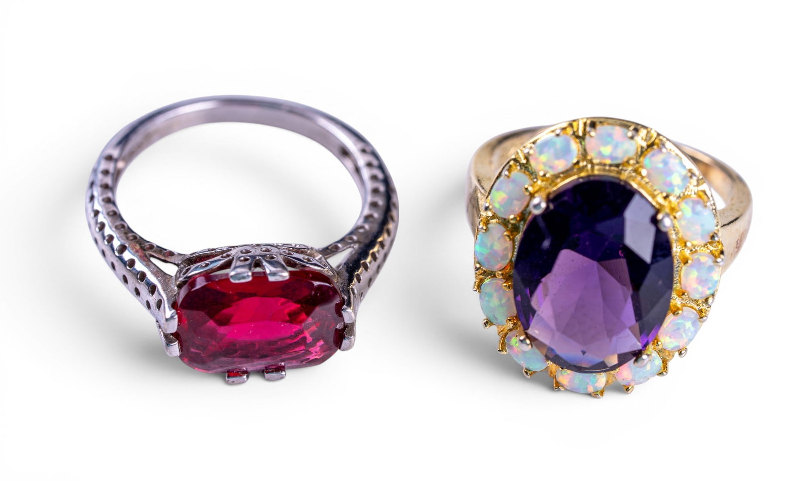 Sterling Silver Cocktail Rings (2): A gold tone sterling silver cocktail ring with amethyst center wreathed by opals, size 9, and a sterling silver cocktail ring with red cut stone center, size 10. Total weight is approx. 0.35oz.