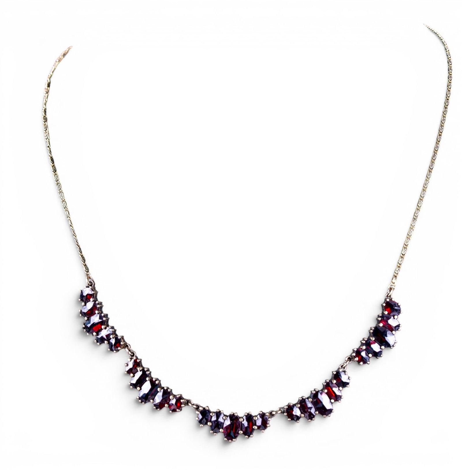 Early Silver and Garnet Necklace: An early silver necklace marked 'NORM' featuring graduated cut garnet stones, measures approx. 9" L on the drop, weighs approx. 0.35oz.