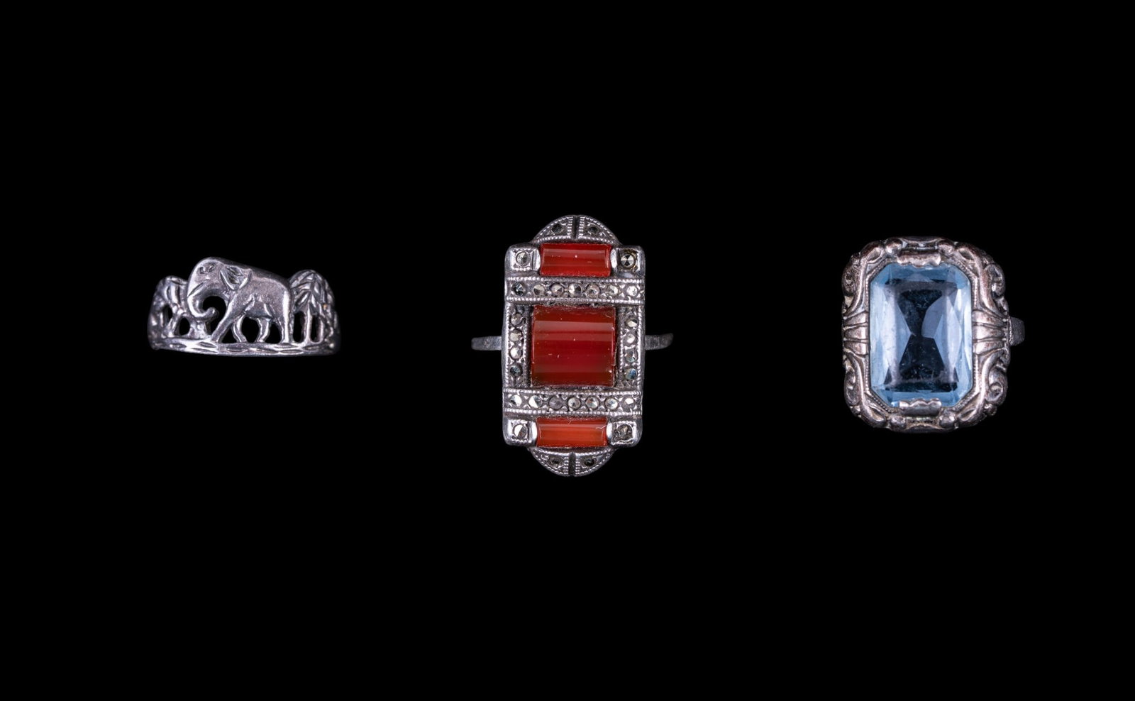 Antique Sterling Rings (3): A collection of sterling rings including an Art Deco Navette ring featuring marcasite and carnelian early figural elephant ring, and an Art Nouveau ring featuring a blue topaz ore aquamarine. Sizes ra
