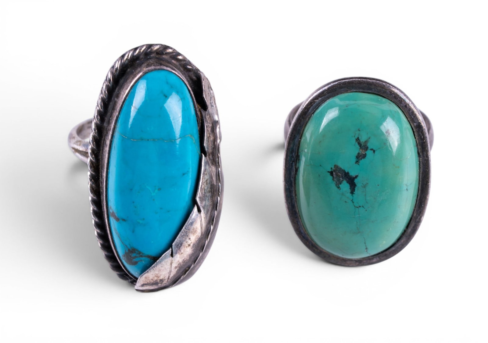 Turquoise and Sterling Rings: An signed Navette silver ring featuring a feather design over a turquoise cabochon and an oval green turquoise cabochon in a sterling setting. Sizes range from 7 to 8, total weight is approx. 0.65oz.