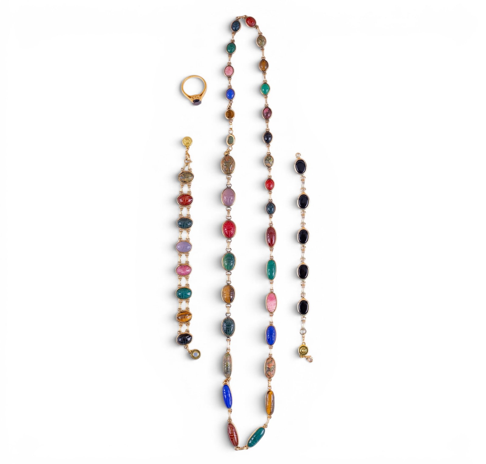Scarab Jewelry and Sterling Ring: A graduated gold tone scarab necklace, approx. 15" L on the drop, an onyx and gold tone bracelet, a scarab and gold tone bracelet, and a gold tone sterling ring with oval cut garnet center. Ring size 