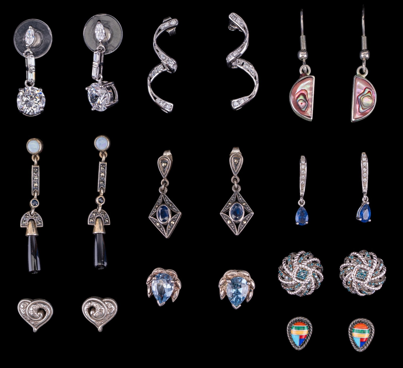 Sterling Silver Earrings (10 prs): A collection of ten pairs of sterling silver pierced earrings featuring abalone inlay, facet cut stones, opal, onyx, and marcasite. Total weight is approx. 1.15oz.