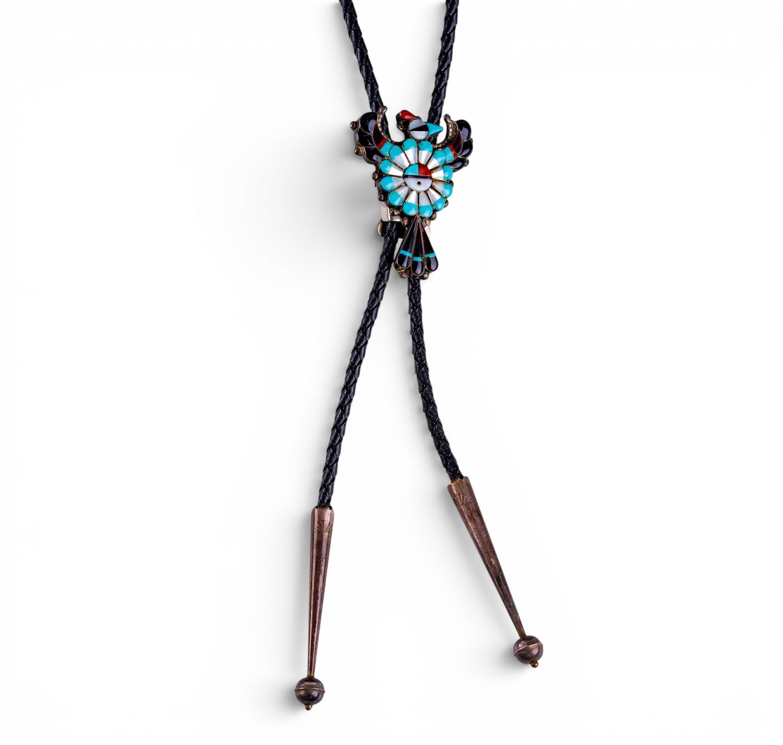 Sterling and Stone Inlay Bolo Tie: A braid leather cord bolo tie featuring etched sterling tips and a turquoise, onyx, coral, and mother of pearl inlay thunderbird clip, hand signed on the reverse section of the tail feathers, total we
