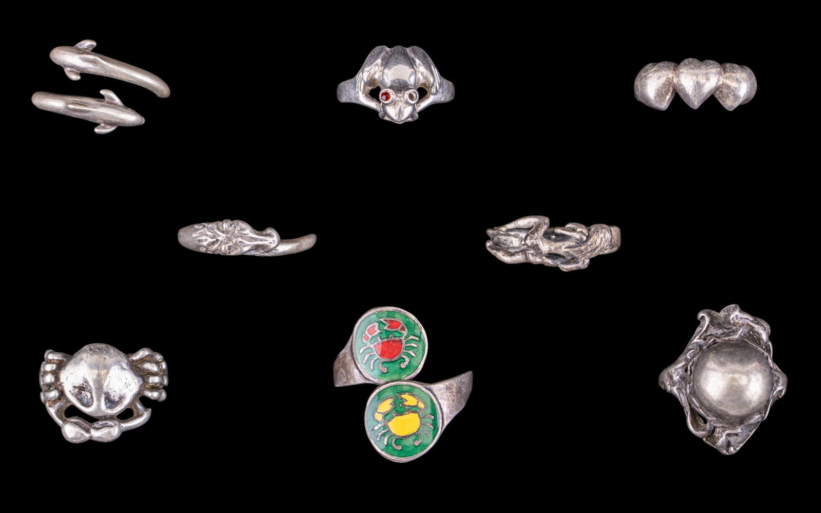 Sterling Silver Figural Rings (8): A collection of figural sterling silver rings featuring a frog with stones for eyes, note one stone missing, adjustable dolphin, horse head, and enamel crab inlay rings, figural Art Nouveau sphere rin