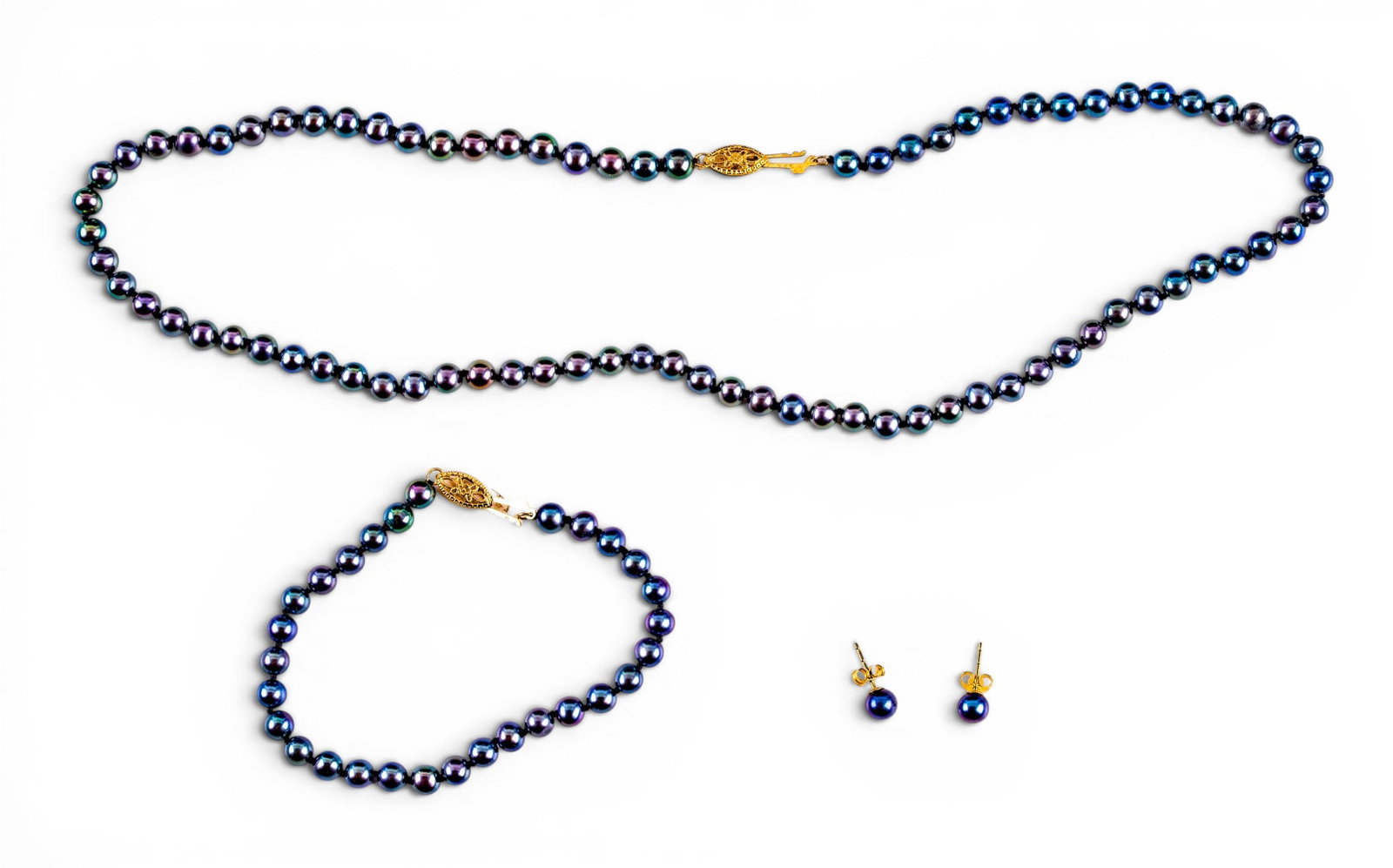 IPS Black Pearl and 14K Jewelry Set: A jewelry set featuring a black pearl necklace, bracelet, and a pair of stud earrings with 14K gold posts and clasps. Clasps are marked for the International Pearl Syndicate. Necklace measures