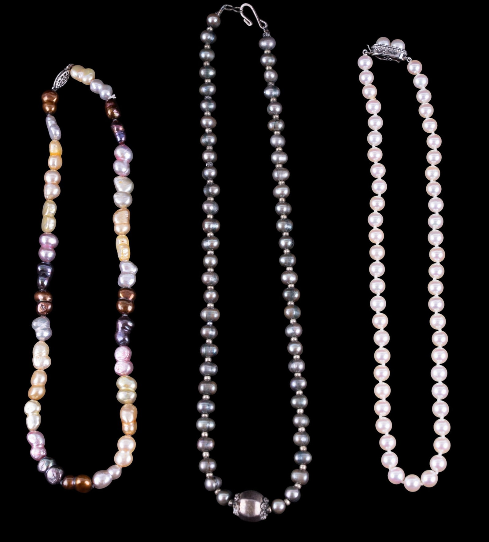 Cultured Pearls and Sterling Necklaces: A collection of three pearl necklaces with sterling clasps featuring black, white, and color cultured and freshwater pearls. Longest measures approx. 9.5" L on the drop.