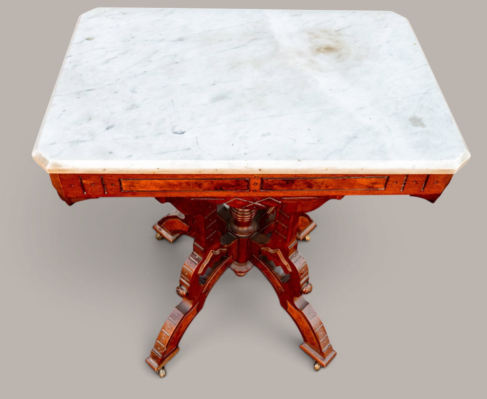 Victorian Walnut Parlor Table w/ Marble Top: Victorian walnut parlor table with rectangular marble top. Base on castor wheels. Measures approx. 31" H x 28.5" W x 19" D.