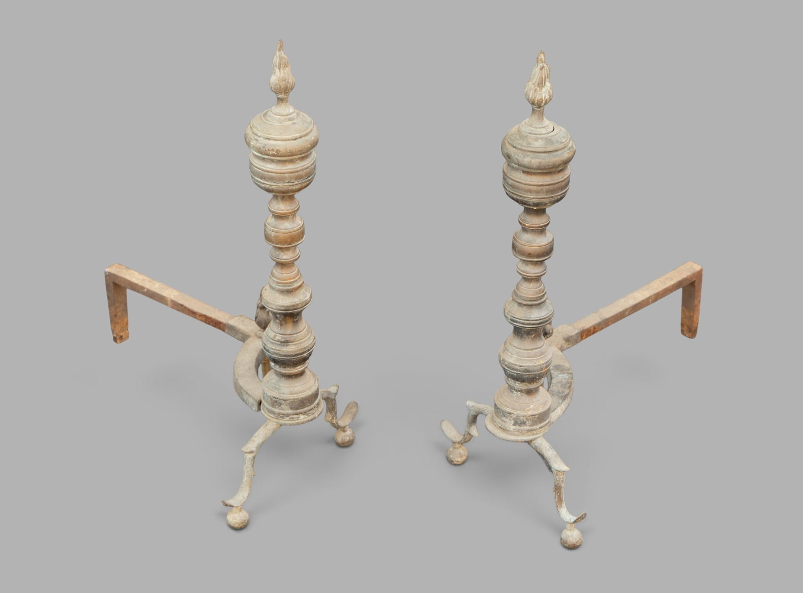 Pair of Antique-Style Andirons: Pair of antique-style andirons with flame finials in the Connecticut River Valley style. Each measures approx. 24" H x 11.5" W x 20" D.