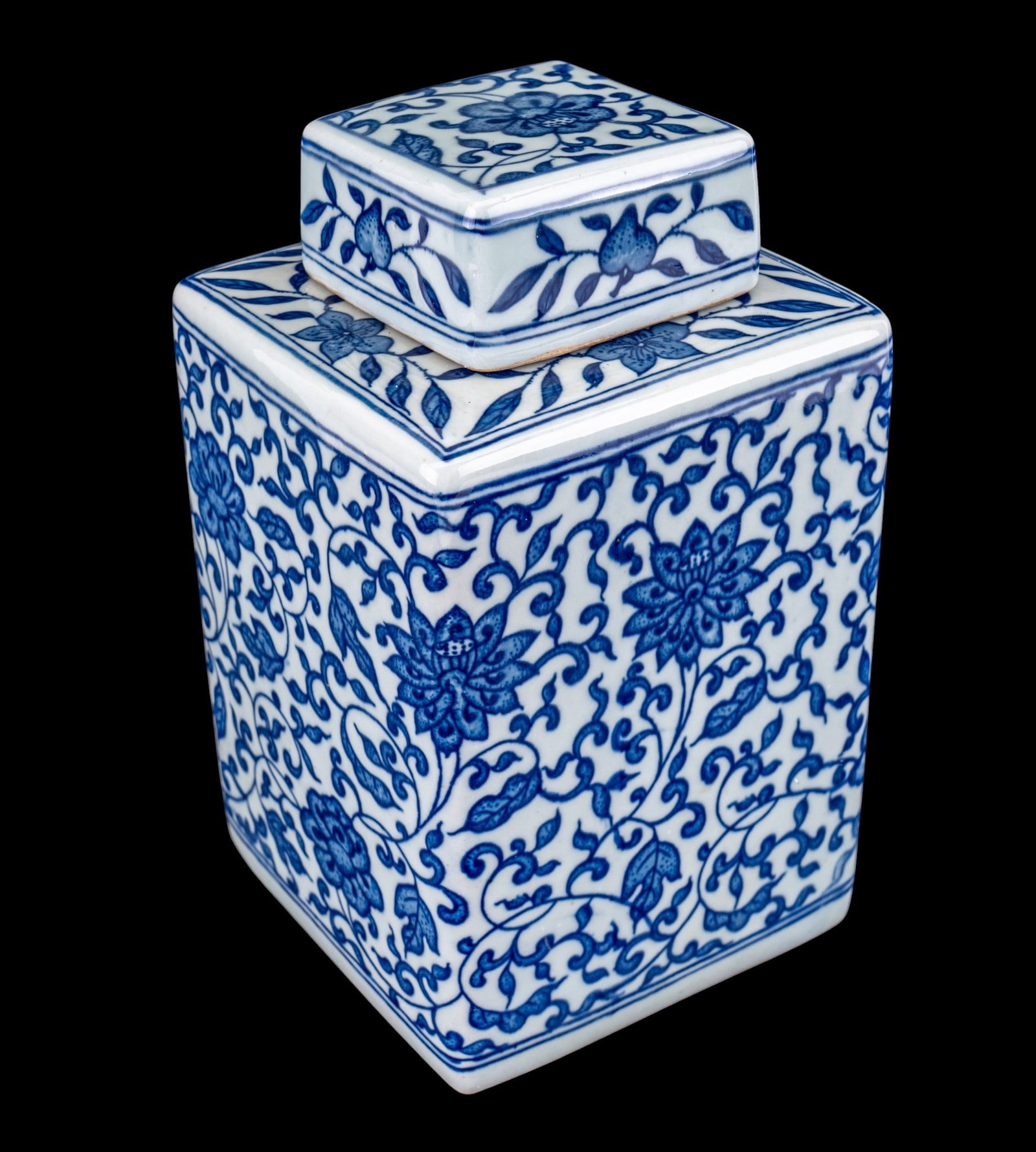 Chinese Blue and White Covered Tea Caddy: Chinese 20th century blue and white porcelain rectangular covered tea caddy decorated with an allover lotus and scrolling foliate pattern. Unmarked to underside. Measures approx. 8.75" H x 5" Square