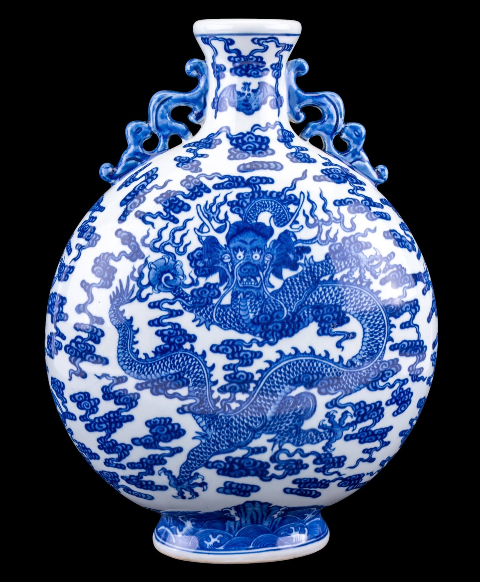 Chinese Blue and White Porcelain Moon Flask: 20th century Chinese blue and white porcelain moon flask featuring an allover design of dragon amidst scrolling clouds. Molded figural handles to neck. Underside bears blue square seal mark. Measures 
