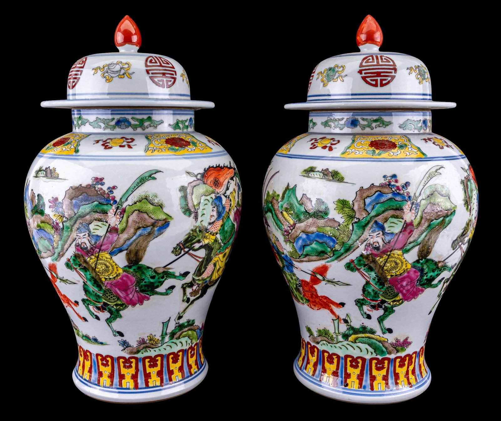 Pair of Chinese Lidded Ginger Jars: Pair of 20th century Chinese lidded ginger jars featuring dynamic scenes of warriors on horseback. Domed lid with finial in red. Shoulder is ringed with yellow floral and scroll border. Each with blue
