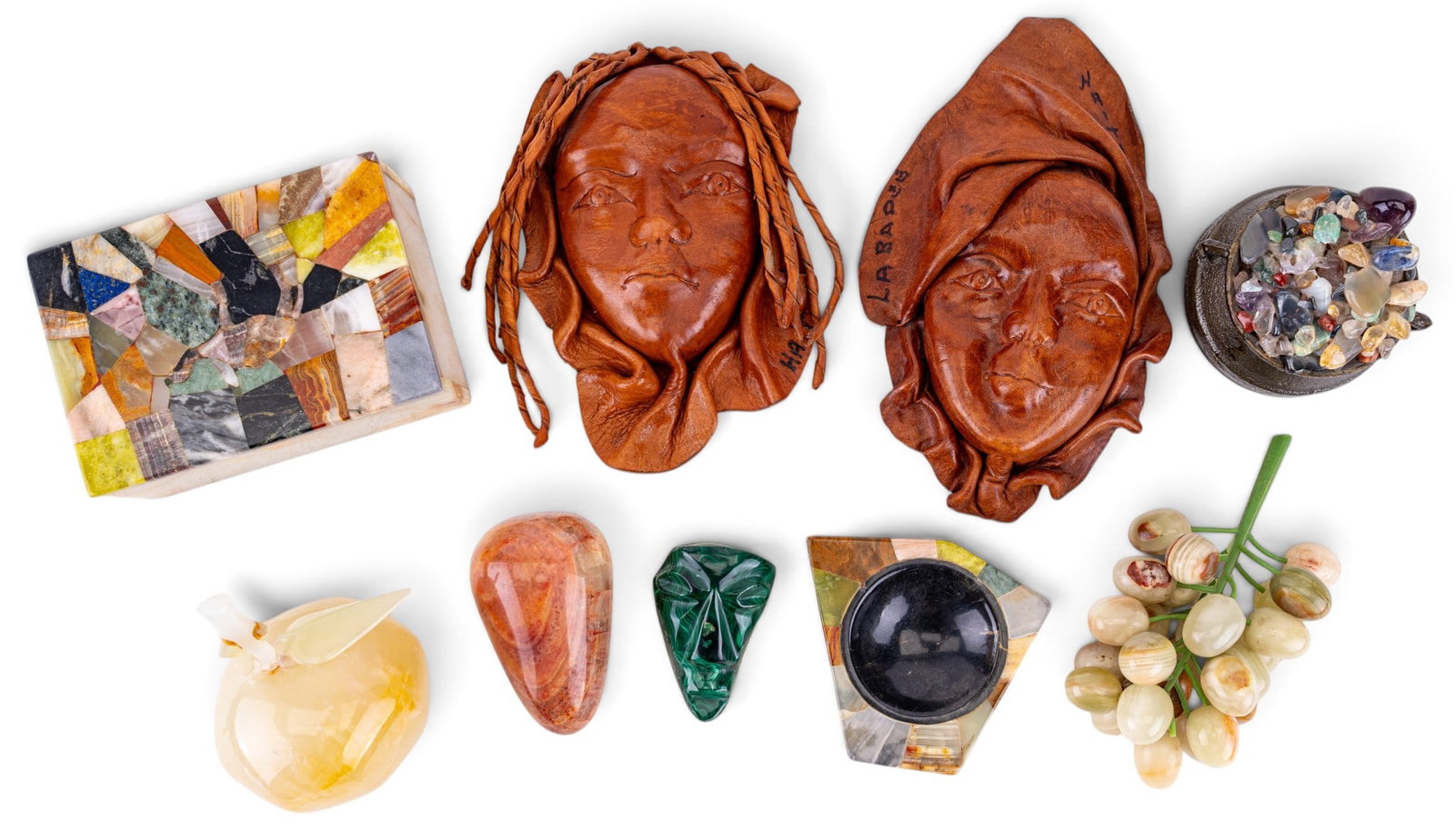Haitian Folk Art & Onyx Decorative Pieces: A set of two molded leather Haitian Folk Art masks, both measure approx. between 7" and 8" H, an onyx and other stone inlay dish, an onyx keepsake box with lid featuring a patchwork design of granite,