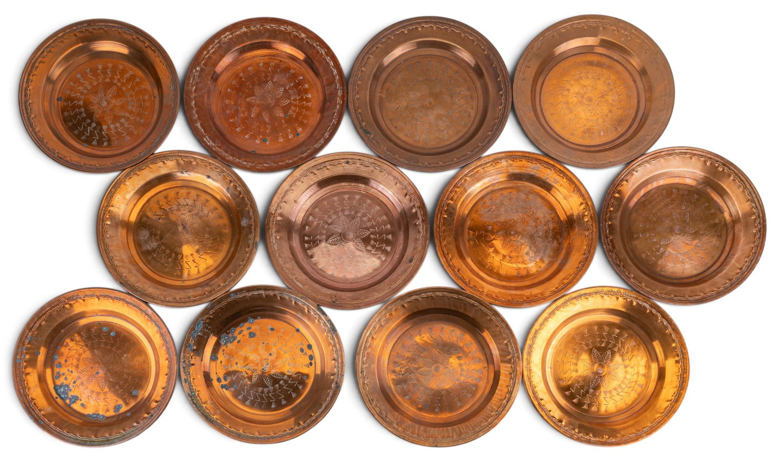 Copper Persian Embossed Charger Plates, Set of 12: Matching set of gorgeously embossed charger plates, total of one dozen (12). Appears to be vintage and hammered by hand. Features a punched floral design. These can be used as serving dishes or as dec