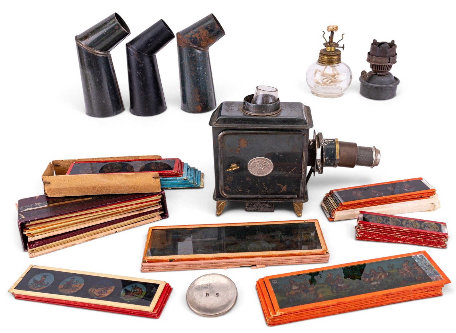 Ernst Plank Magic Lantern and Slides: An early 20th C Ernst Plank Magic Lantern toy with oil lamps and a large assortment of painted glass cartoon slides.