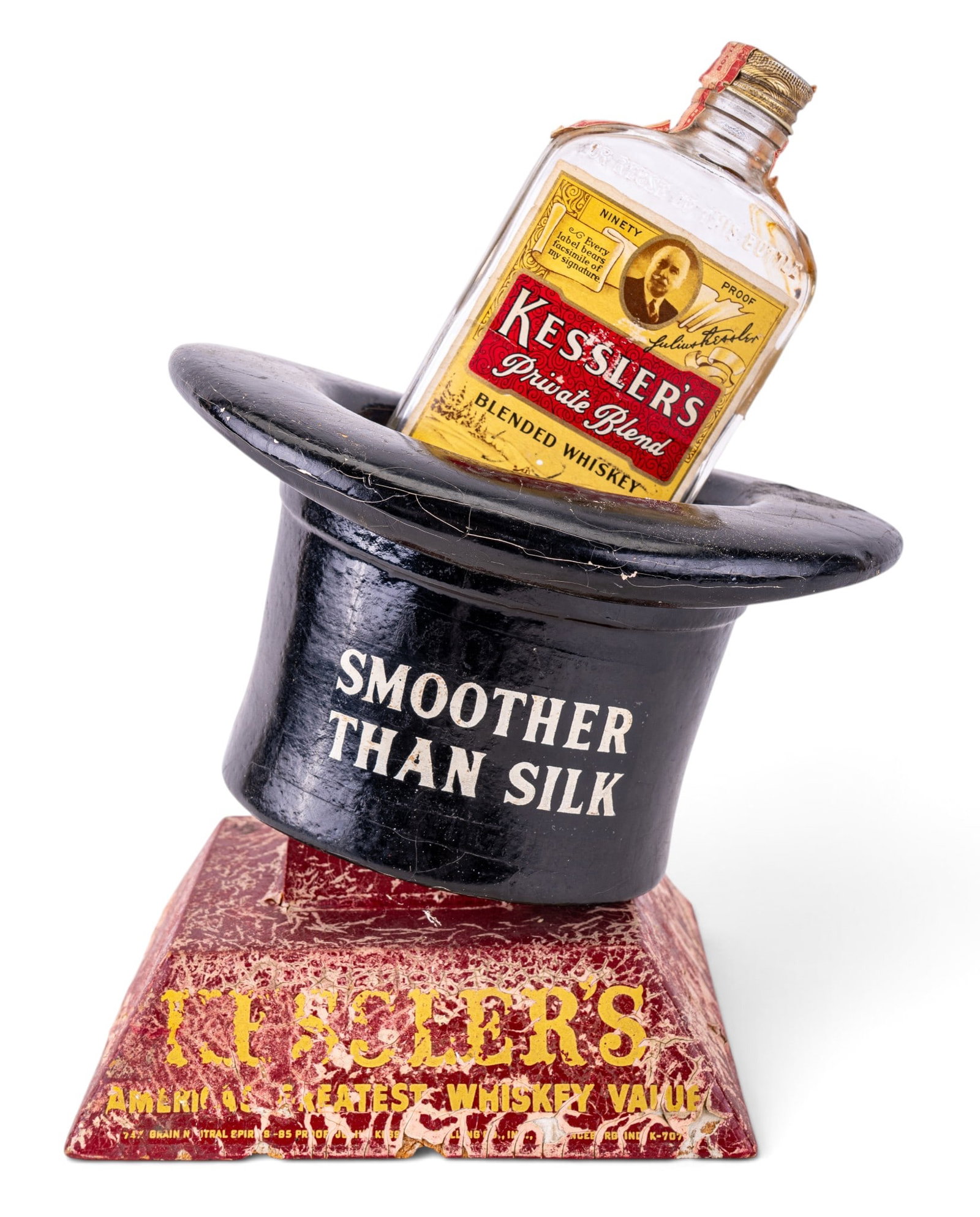 Kessler's Whiskey Advertising Bottle Holder: Vintage Kessler's blended whiskey advertising display fashioned as a top hat with the slogan "Smoother Than Silk" to the front. Base reading "America's Greatest Whiskey Value". Display with bottle mea
