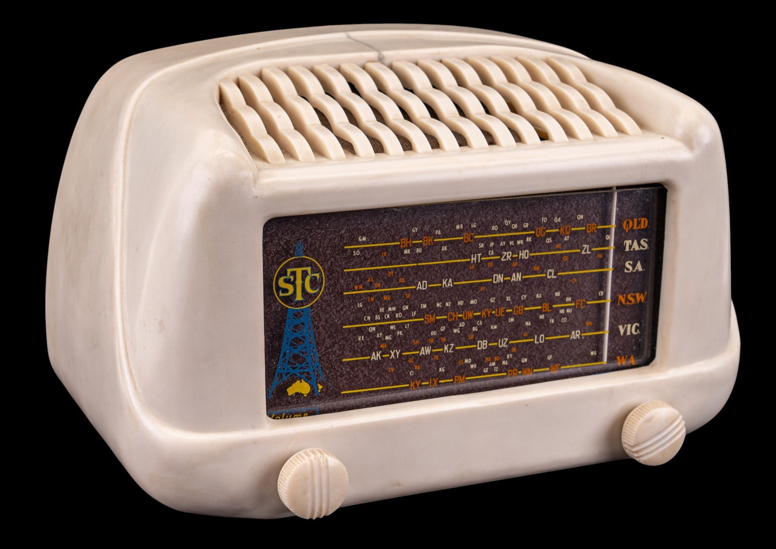 Austrailian STC A4110 "Eiffel Tower" Radio: Australian-made STC Model A4110 tabletop radio, commonly referred to as the "Eiffel Tower" radio. Housed in a white Plaskon case with Australian state station listings to dial. Case has crack to top a