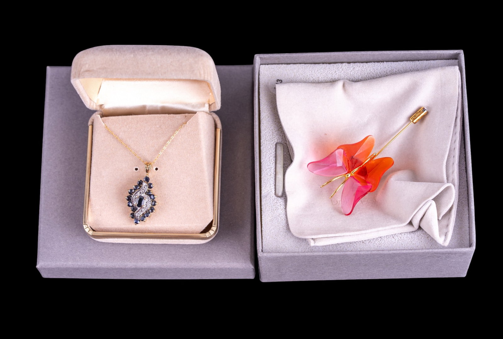 Swarovski Pin and 925 Sapphire Necklace: A gold tone Swarovski pin featuring a cut crystal butterfly from the Paradise style line, includes original box, and a facet cut sapphire and gold tone sterling pendant on a 14K GF chain. Pendant weig