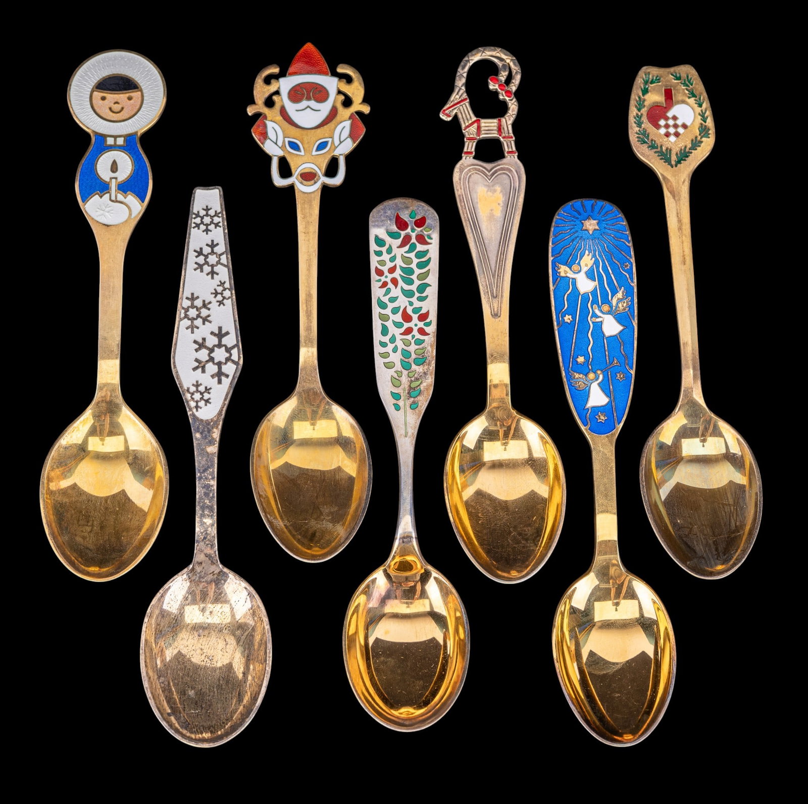7 Danish Sterling Silver Gilt Souvenir Spoons: Seven Danish sterling silver gilt souvenir spoons with polychrome enamel decoration including Christmas and winter motifs. Each marked "Sterling Danmark". Some with dates and makers. Total weight appr