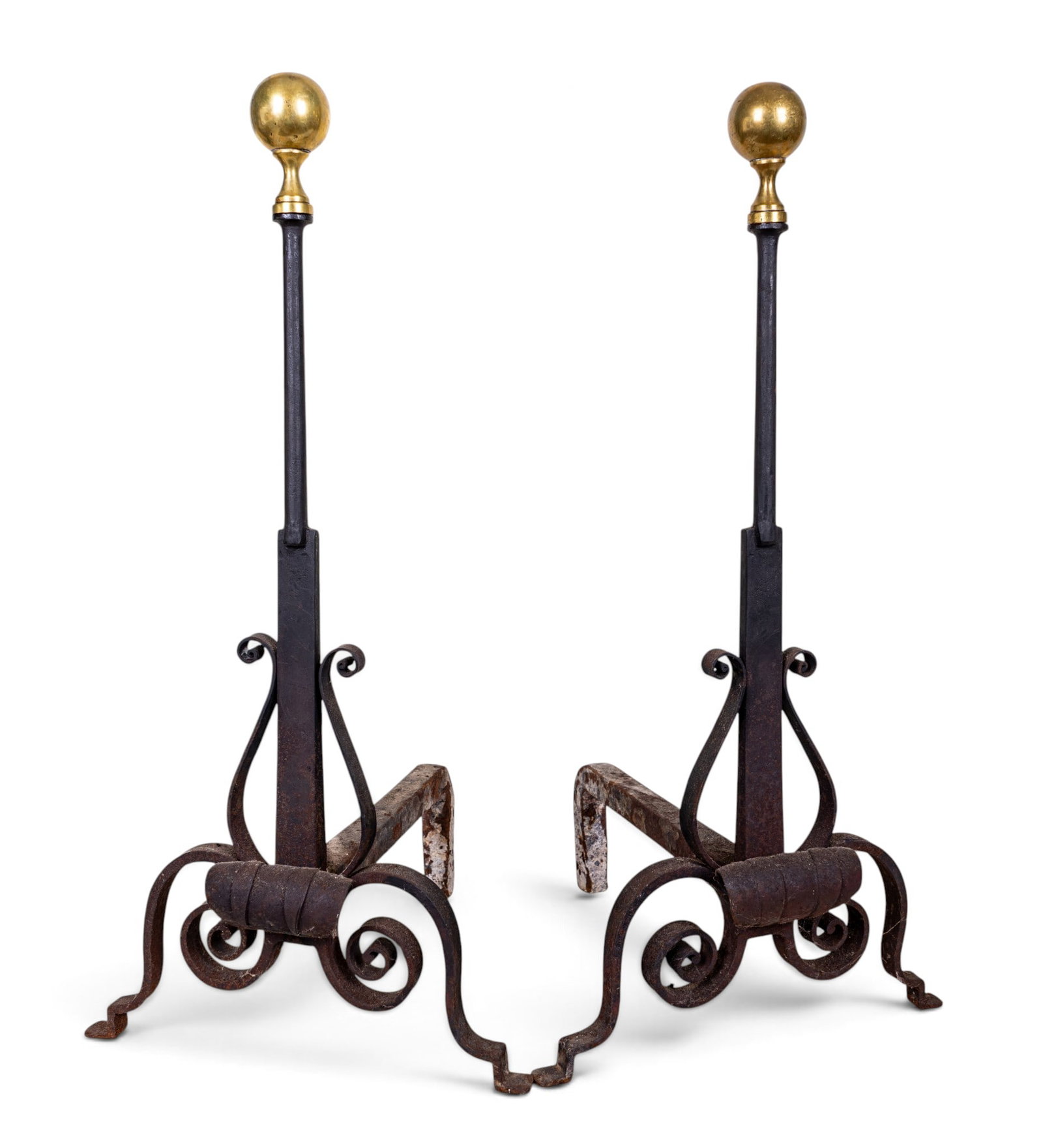 Pair of Brass Fireplace Andirons: Pair of fireplace andirons with tall standards terminating in large spherical brass finials. Each features decorated iron scrollwork at the base, curved feet, and iron log supports. Each measures appr