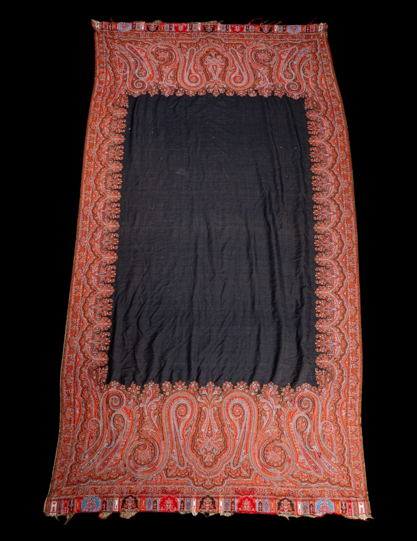 Large Paisley Shawl ~4.5' x 9.5': Machine-made textile shawl featuring a maroon / red paisley pattern with scrolling floral and foliate motifs around a center rectangle of black. Measures approx. 4'6" x 9'5". Could use as a table clot
