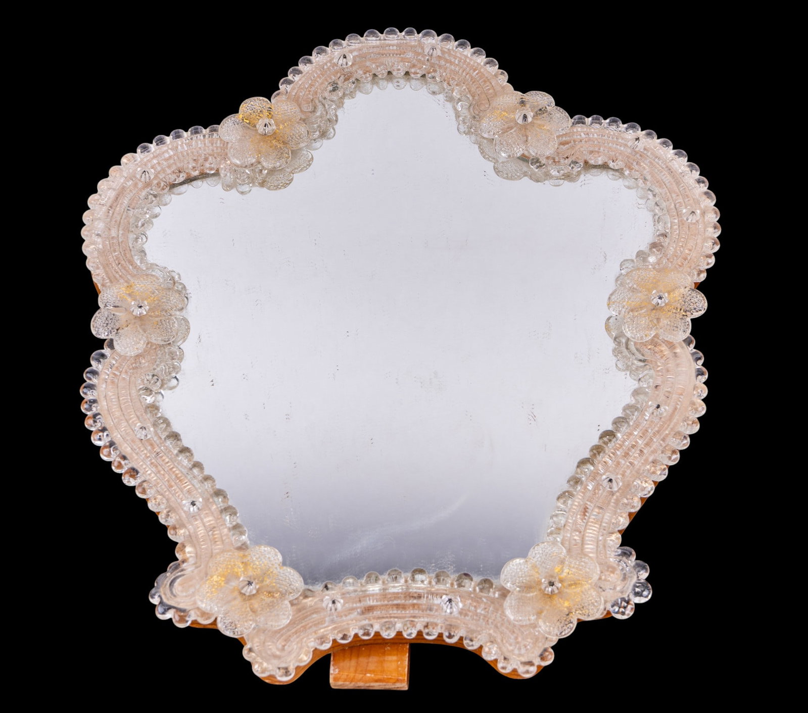 Vintage Venetian Murano Glass Wall Vanity Mirror: Vintage Venetian mirror for tabletop or wall vanity. Murano glass. Features classic scalloped silhouette, framed by intricate clear glass work. Border heavily embellished with glass floral blossoms an