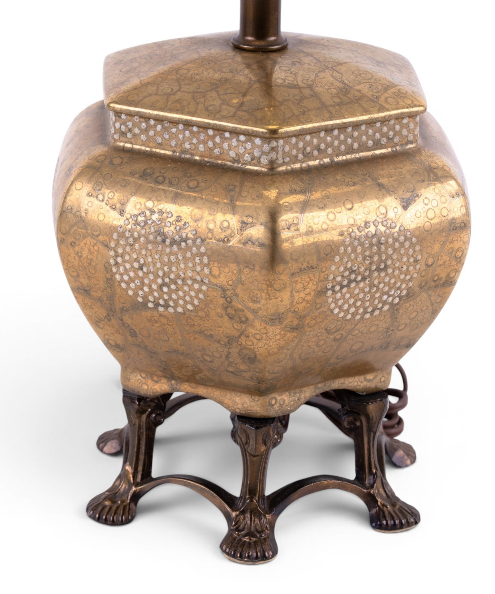 Asian Gold Tone Lamp on Unusual Brass Stand: An Asian porcelain table lamp in gold tone paint on 6 connected brass feet for the base and a later metal shade. Untested, measures approx. 12" to the socket, 20" to the finial.
