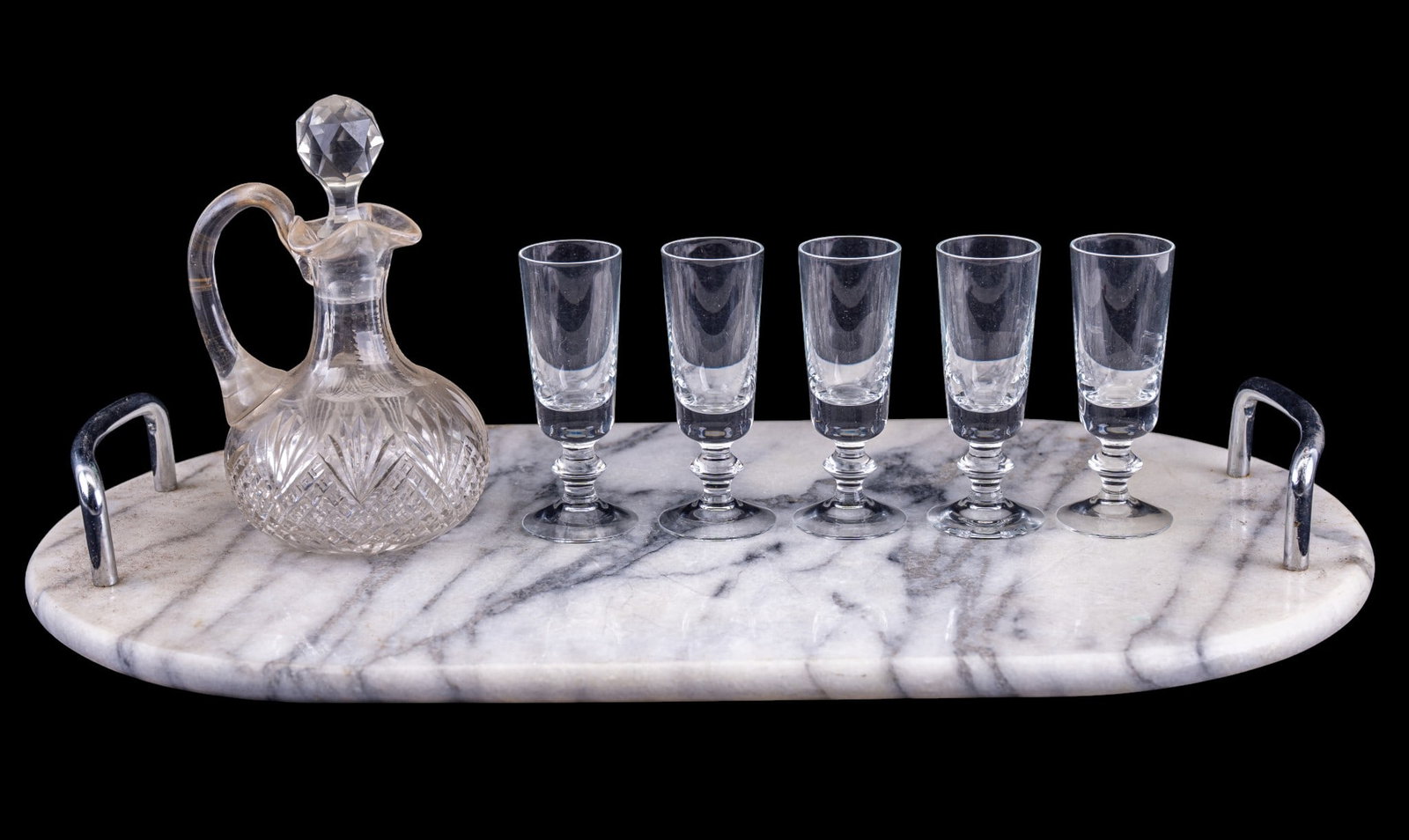 Marble Serving Tray, Cut Glass Cruet, Coridals: Serving group comprising an oval white and gray veined marble serving tray with rounded ends and raised metal handles, accompanied by a cut glass cruet with applied handle, faceted stopper, and cut