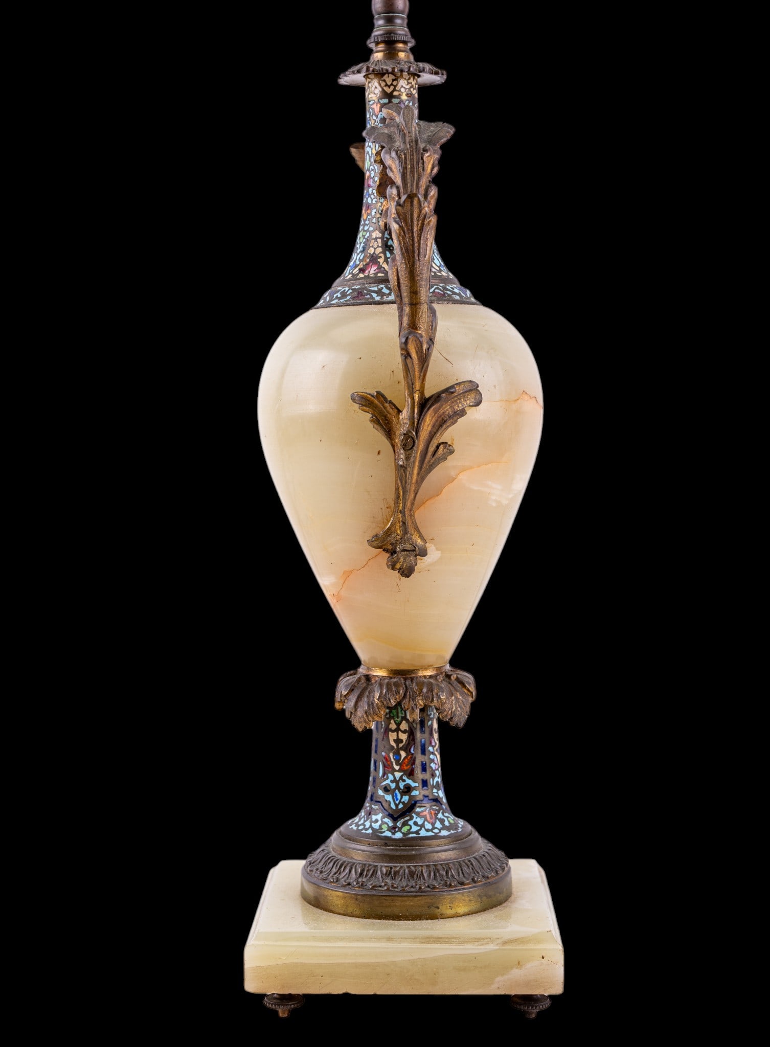 Onyx, Bronze, & Cloisonne Table Lamp: Decorative table lamp featuring a large polished onyx urn-form body mounted with ornate bronze foliate handles and multicolored cloisonne enamel decoration to the neck and lower support. Raised on a b