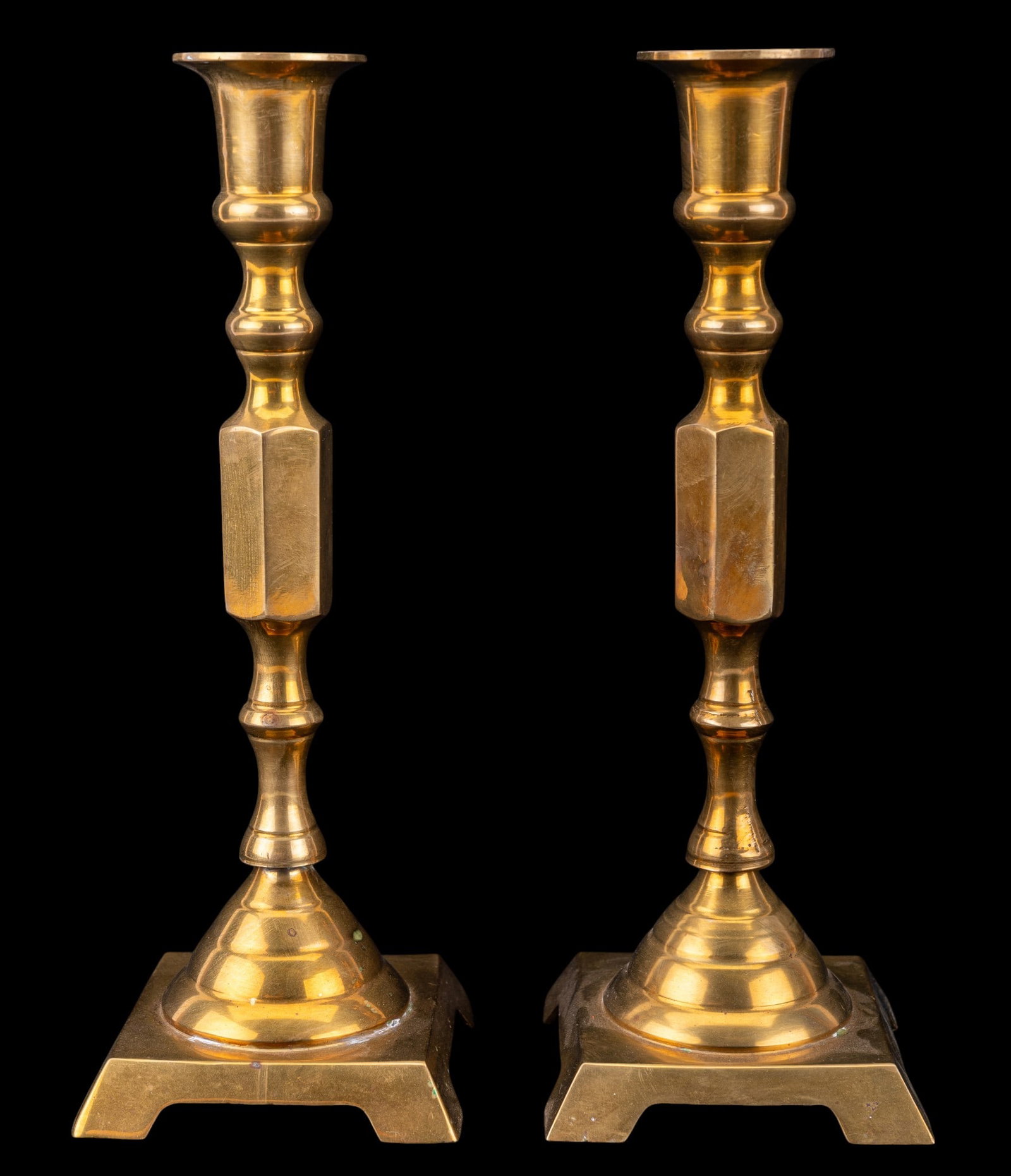 Matched Pair of Brass Candlesticks: Matched pair of vintage solid brass taper candlestick holders featuring a distinct hexagonal midsection. Each measures approx. 10" H x 3.5" Square at base. Came from fine estate located in Chestnut