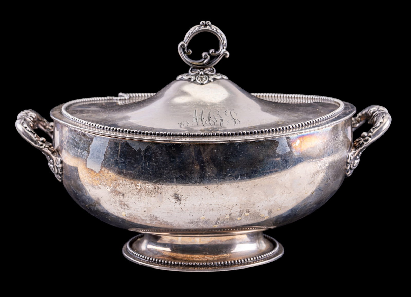 Wilcox Quadruple Plate Monogrammed Tureen: An early Wilcox Silver Plate Co. quadruple plate soup tureen featuring a monogram, ornate floral handles, bead accent. Measures approx. 13" W x 9" D x 9" H. Note there is no ladle.