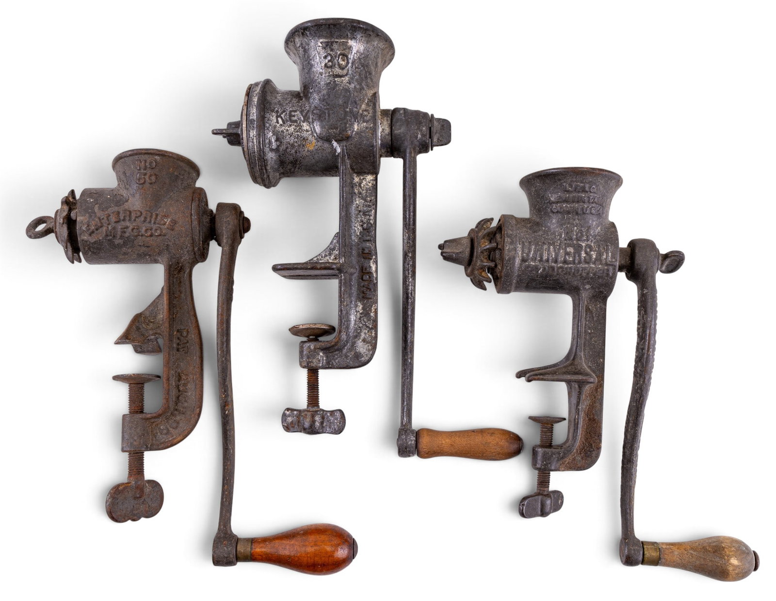 Early Iron Meat Grinders: A collection of three early iron table vise meat grinders featuring brands such as Keystone and Enterprise.